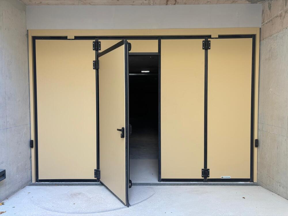 Porta de garagem em harmónio com porta de emergência integrada