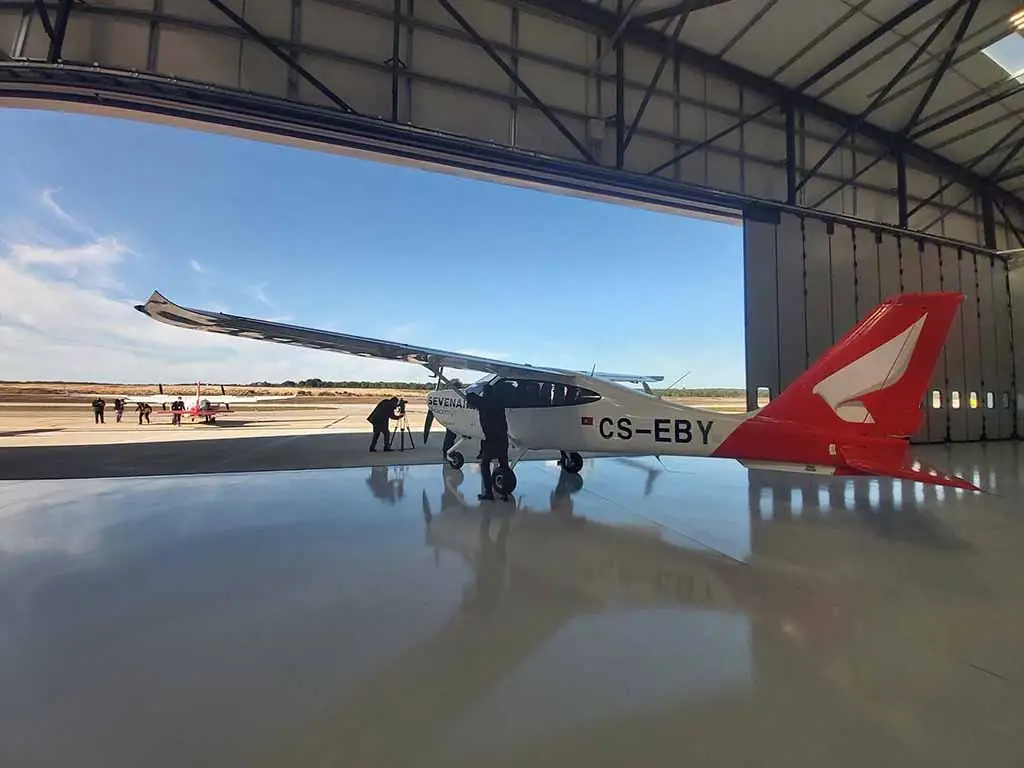 Avião dentro do hangar de um aeródromo no Alentejo, com a porta de harmónio BREDA Apollo aberta ao fundo
