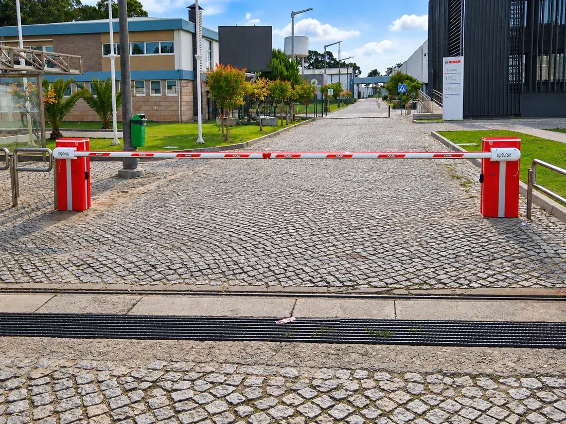 Duas barreiras automáticas FAAC B680H com hastes frente a frente na entrada de um centro empresarial em Estarreja