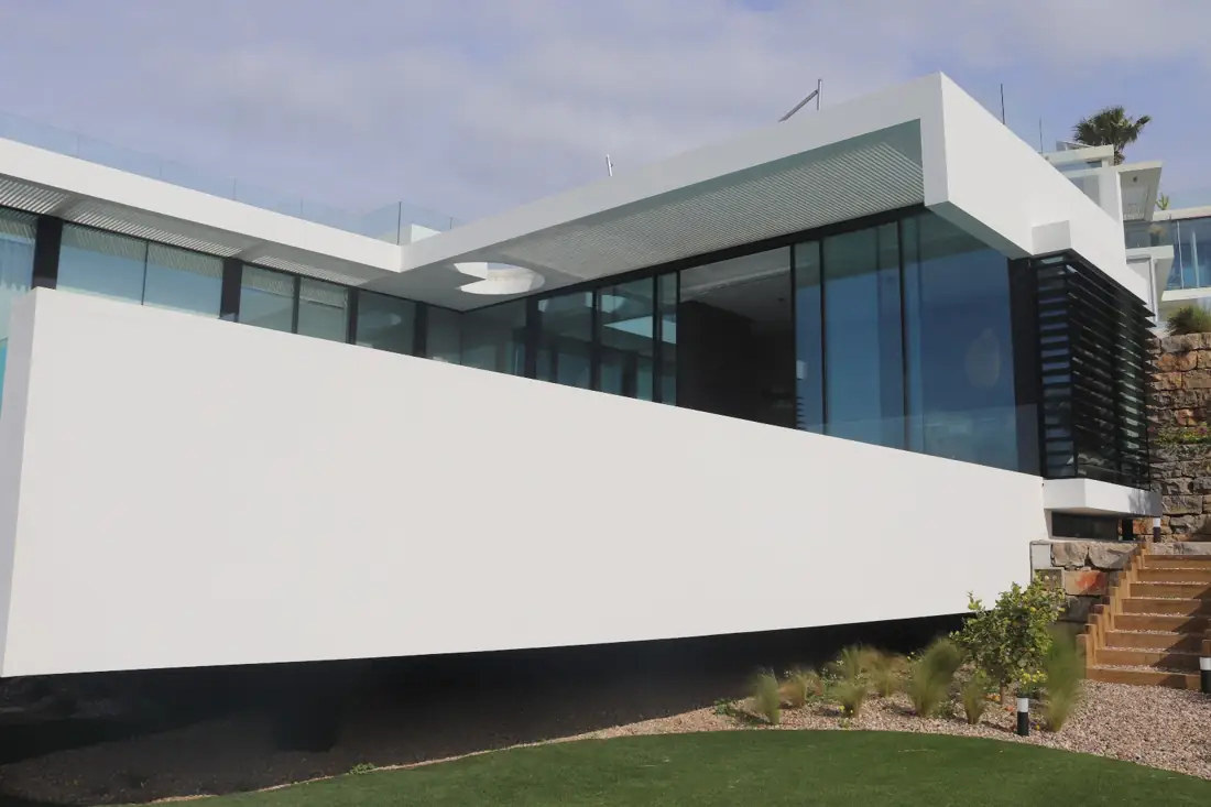 Vista exterior da moradia na Quinta do Lago com os vãos envidraçados de correr