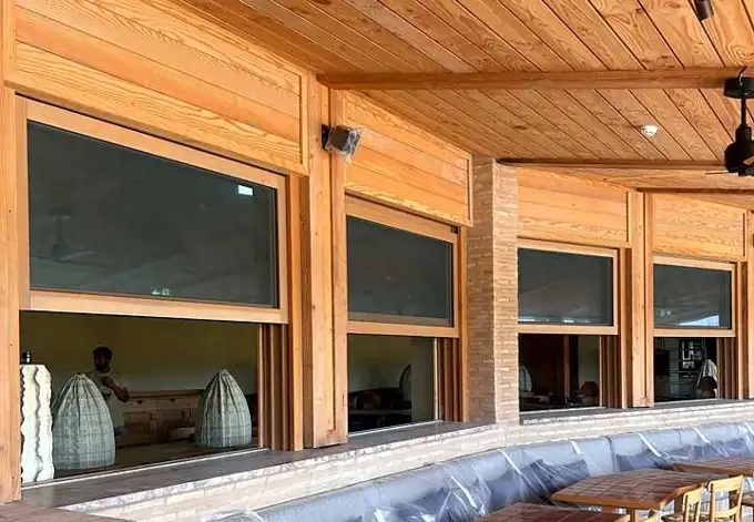 Janelas de guilhotina em madeira motorizadas abertas no restaurante Na Praia, Comporta