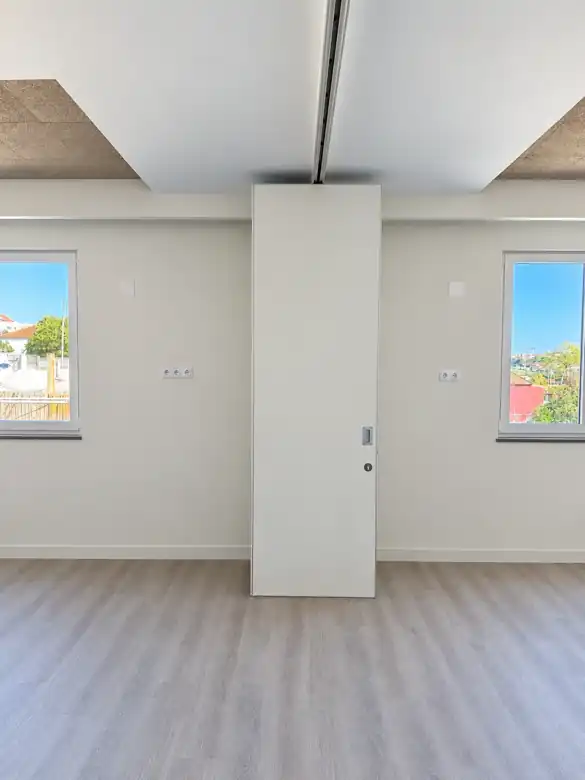 Parede móvel de harmónio com painéis recolhidos ao centro no Almada International School