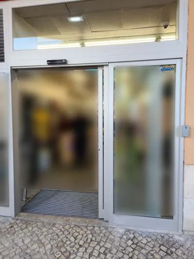 Porta automática de correr com caixilho Refral RF-Large e bandeira superior