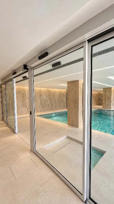 Porta automática com caixilho Refral RF34 junto a piscina interior