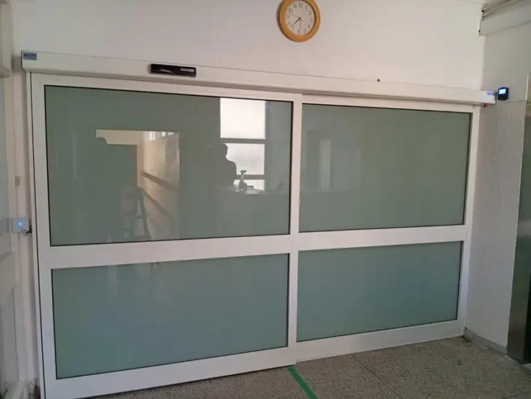 Porta automática GU econoMaster com caixilho RF-Large, almofada central e vidro laminado fosco numa unidade hospitalar em Santa Maria da Feira