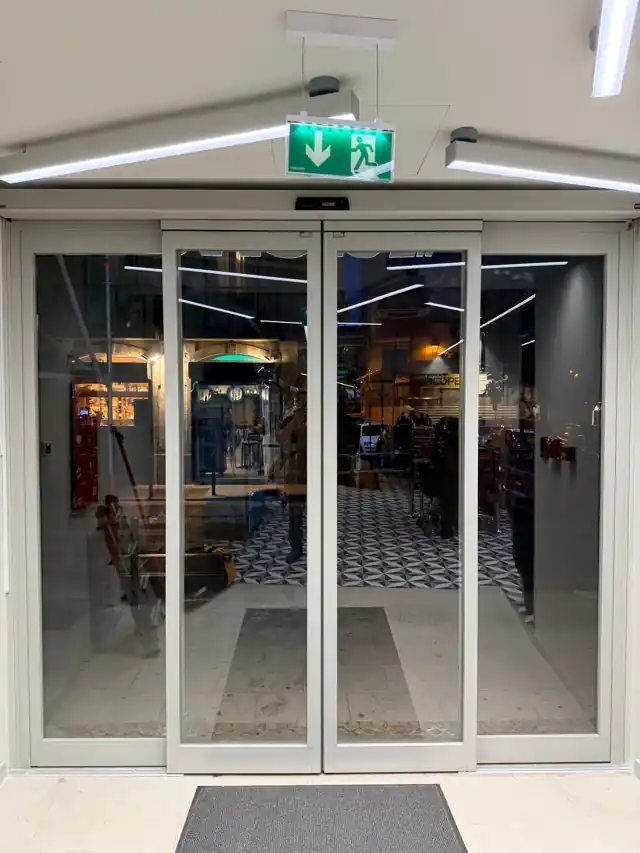 Porta automática de saída de evacuação com caixilho RF-Breakout, vista do interior da loja