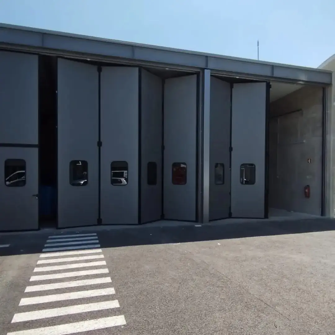 Portas de harmónio Adone abertas, com os vãos livres para a passagem de viaturas