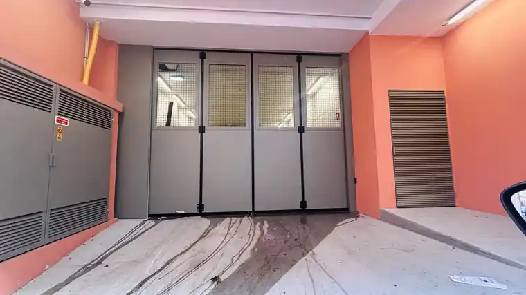 Porta de harmónio BREDA Apollo com visores em rede quadrada na entrada do parque de estacionamento do Hotel Tivoli Kopke, em Vila Nova de Gaia