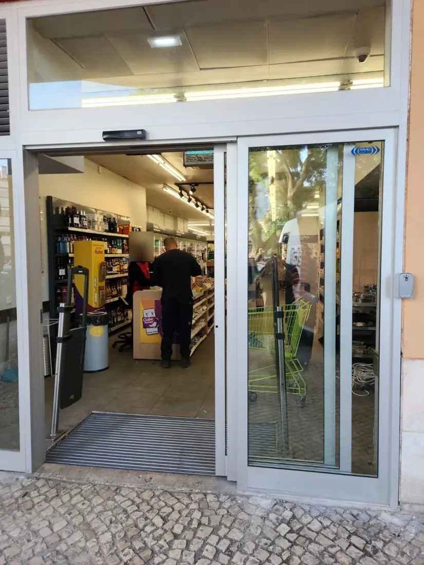 Porta automática telescópica aberta na entrada de uma loja Auchan em Lisboa