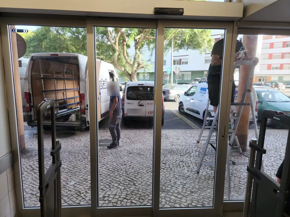 Porta automática telescópica fechada, vista do interior da loja Auchan