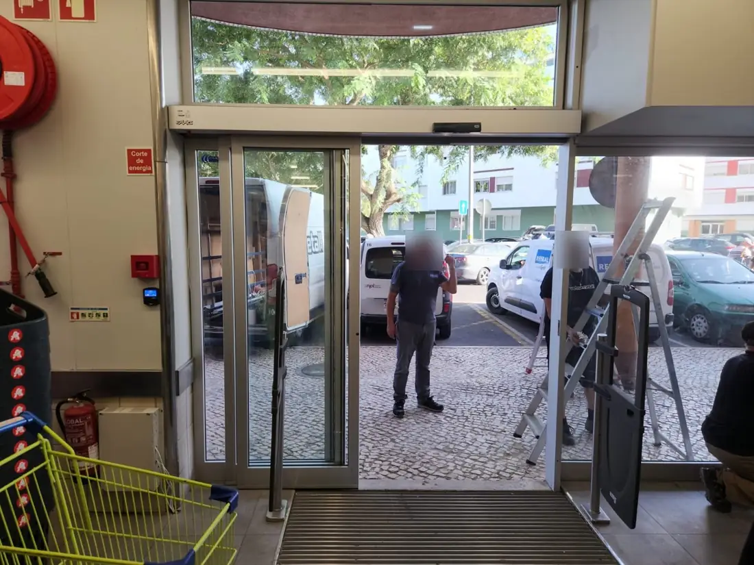 Porta telescópica aberta, com as folhas sobrepostas, na loja de retalho em Lisboa