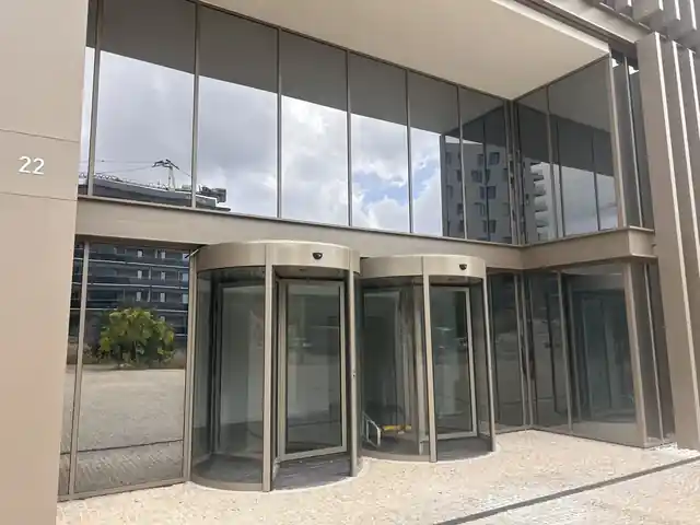 Pormenor das portas giratórias RevoLine com acabamento em tom bronze coordenado com a fachada do Edifício Paço de Rei