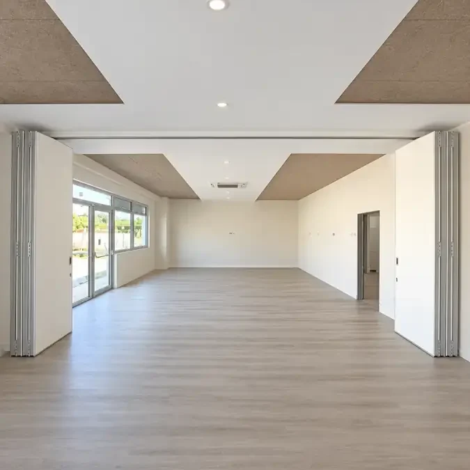 Paredes móveis de harmónio WINAB recolhidas, com as duas salas de aula unidas num só espaço na Almada International School
